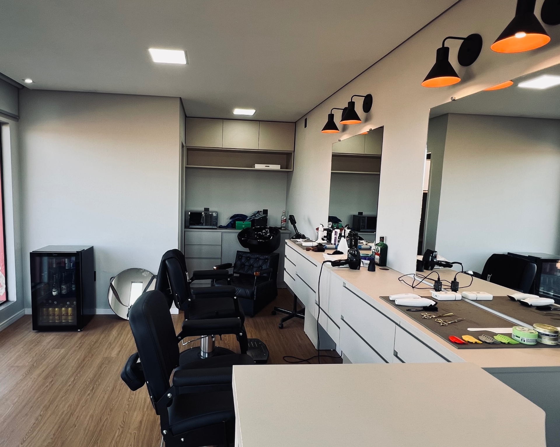 Salão completo da Felino Barbearia com cadeiras e bancada